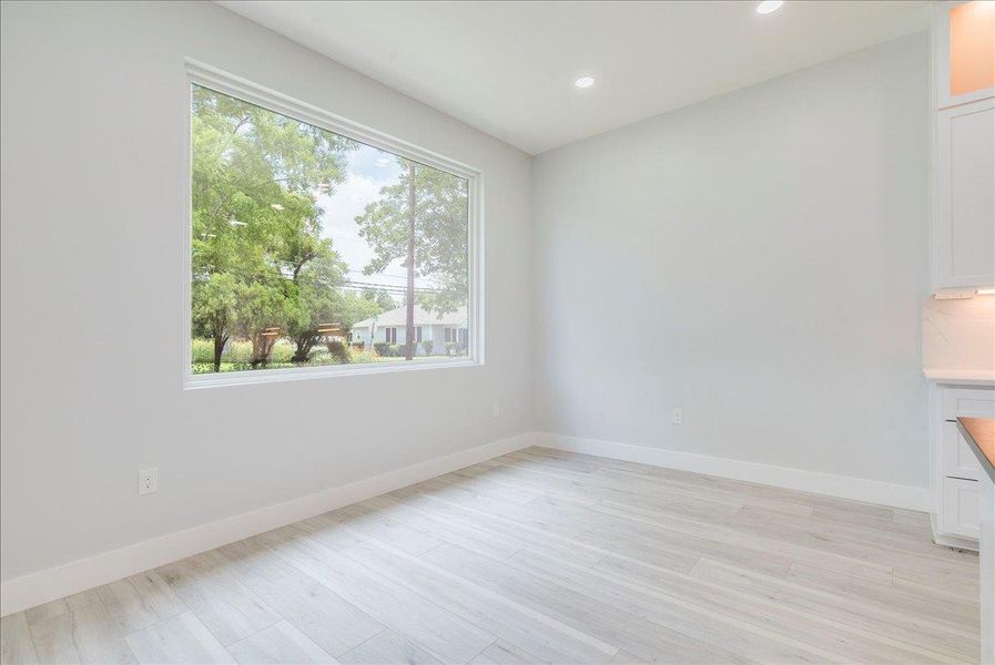 Dining area with light wood-style floors and recessed lighting