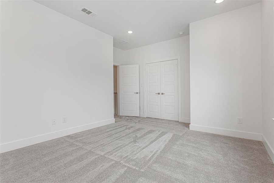 Unfurnished bedroom with light colored carpet and a closet