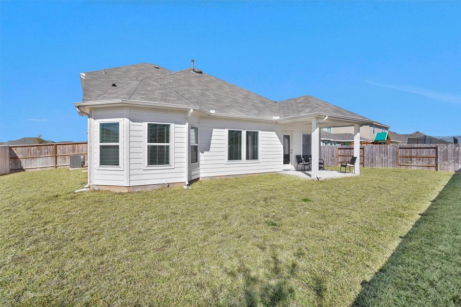 This spacious backyard features a covered patio, fully fenced yard, and plenty of open green space—perfect for outdoor entertaining, play, or future landscaping.