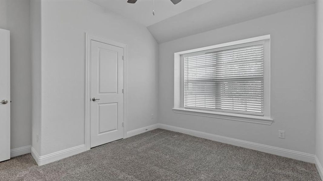 Unfurnished bedroom featuring lofted ceiling, carpet floors, and ceiling fan