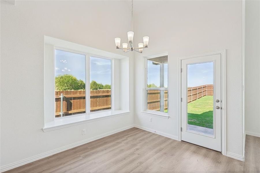 Unfurnished dining area with a chandelier and light wood-type flooring