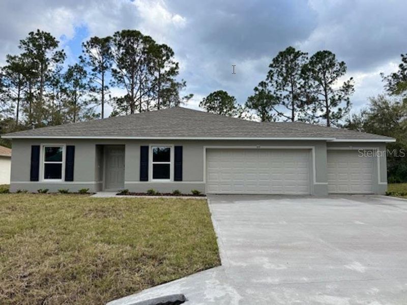 Front exterior of a new home in Palm Coast: Value Collection, Palm Coast, FL, highlighting curb appeal (Image 1).