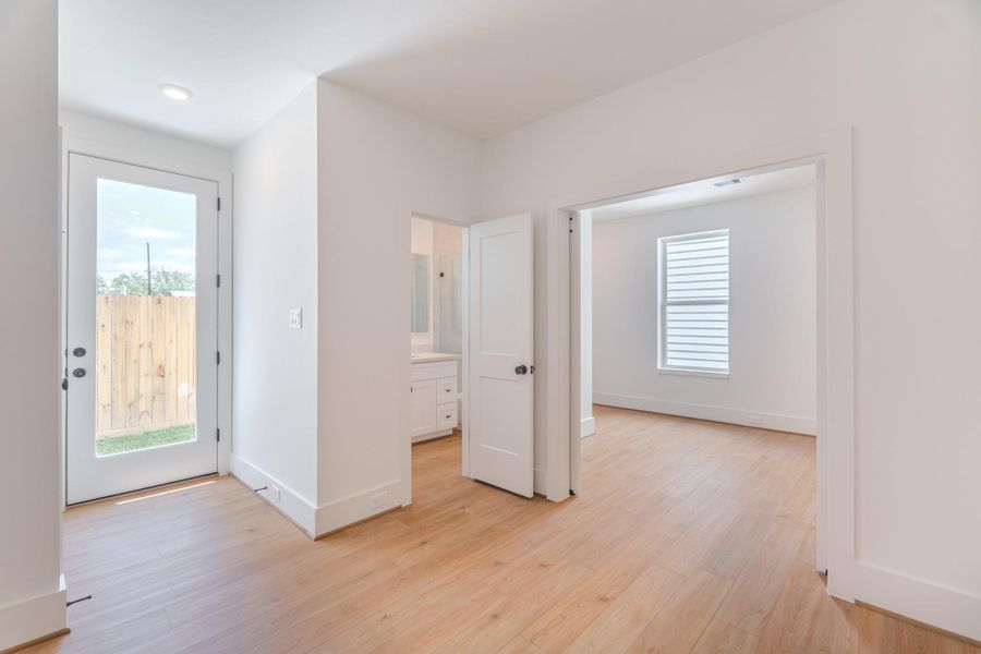 Bright and welcoming entryway with light wood flooring, leading to a room with a large window. There's a glass door to the outside and a small hallway to a bathroom with white cabinetry.Photo Disclaimer: Photos are representative of the community and may depict a similar floor plan, model home, or previously completed residence. Bright and welcoming entryway with light wood flooring, leading to a room with a large window. There's a glass door to the outside and a small hallway to a bathroom with white cabinetry.Photo Disclaimer: Photos are representative of the community and may depict a similar floor plan, model home, or previously completed residence.