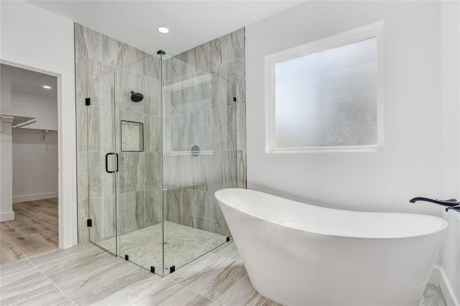 Bathroom featuring hardwood / wood-style floors and plus walk in shower