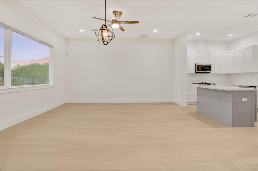 Light-filled dining and living area with oversized window and open layout for flexible living.