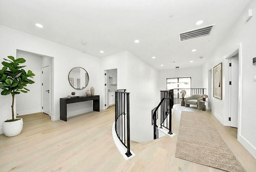 Sunlight filters through the upstairs landing, highlighting its spacious layout and creating a welcoming transition between rooms.