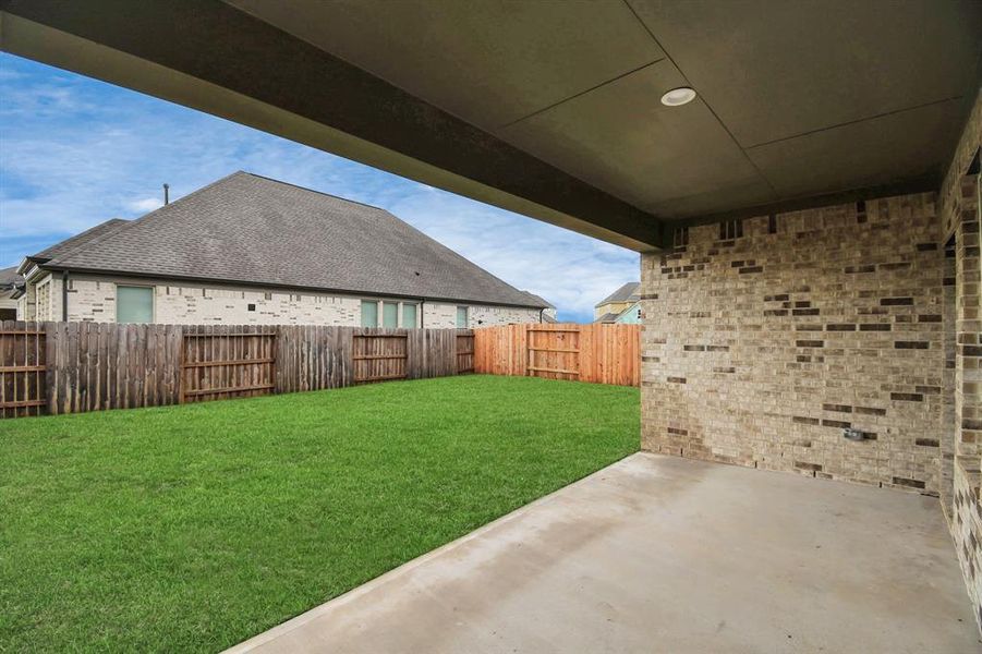 Experience outdoor living at its finest on this expansive covered patio, thoughtfully designed for BBQs and delightful outdoor dining. Sample photo of completed home with similar floor plan. Actual colors and selections may vary.