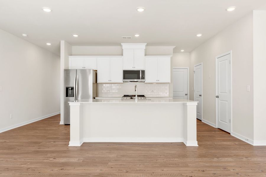 A kitchen with white cabinets.