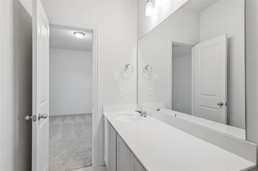 Bathroom featuring light colored carpet and vanity Bathroom featuring light colored carpet and vanity