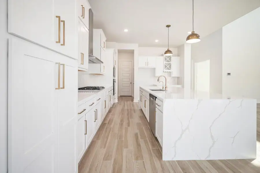 The gourmet kitchen showcases white cabinetry, quartz countertops, and high-end finishes that exude timeless luxury. Designed with both beauty and function in mind, this stunning space offers a clean, modern aesthetic complemented by premium fixtures and thoughtful details—perfect for both everyday living and elegant entertaining.