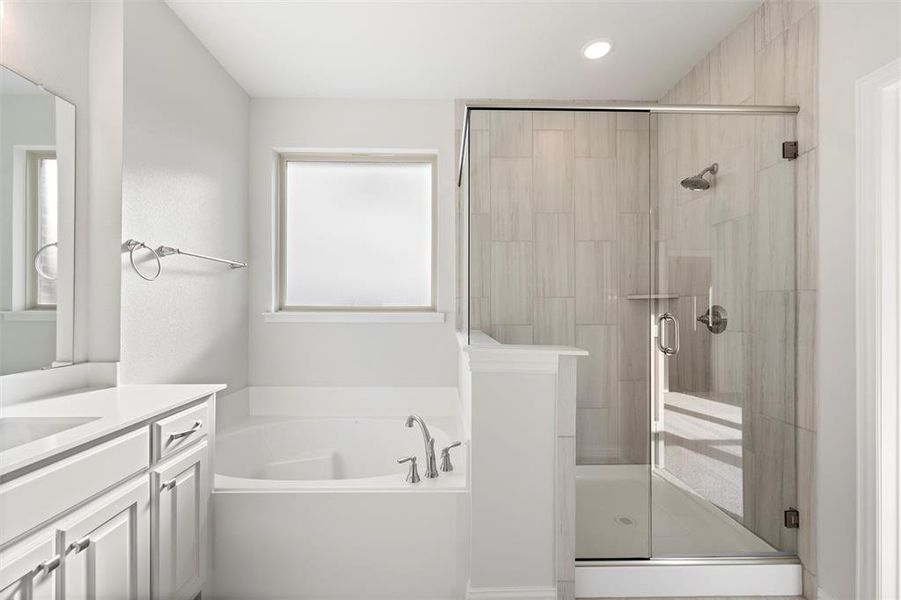 Bathroom with a bath, vanity, a stall shower, and recessed lighting
