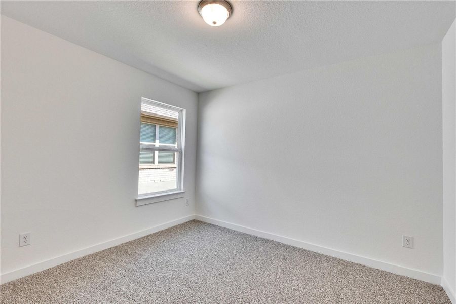 Spare room featuring carpet floors and a textured ceiling Spare room featuring carpet floors and a textured ceiling