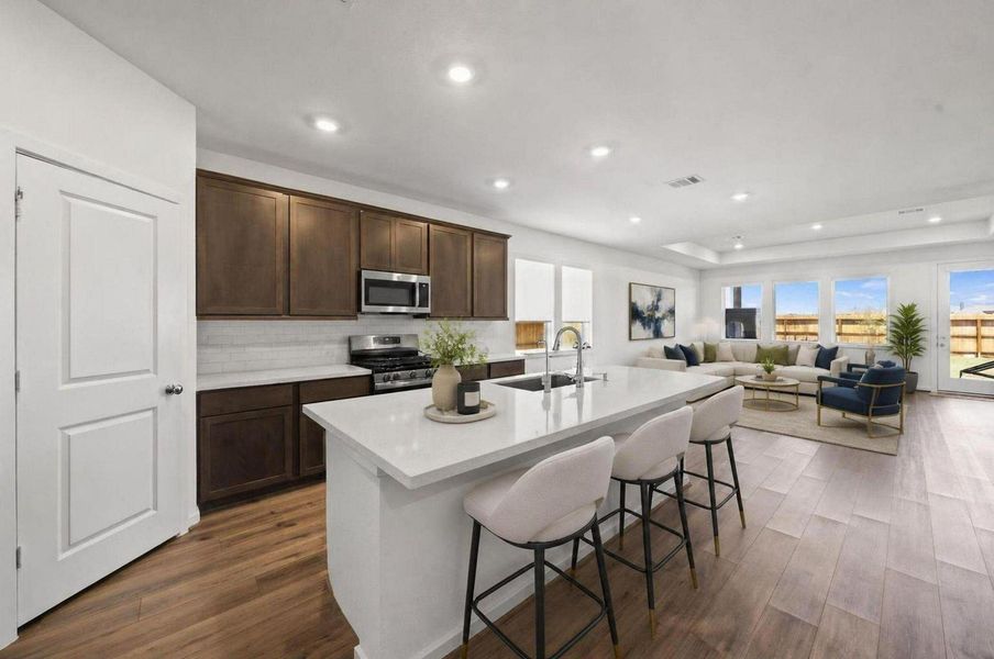 The kitchen island creates the centerpiece of the main level with seating, prep space, and quartz surfaces. Its open position keeps the kitchen connected to the dining and living areas. Virtually Staged. The kitchen island creates the centerpiece of the main level with seating, prep space, and quartz surfaces. Its open position keeps the kitchen connected to the dining and living areas. Virtually Staged.