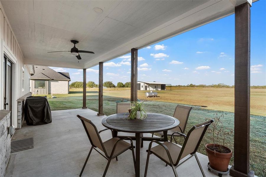 View of patio featuring ceiling fan, outdoor dining space, and area for grilling