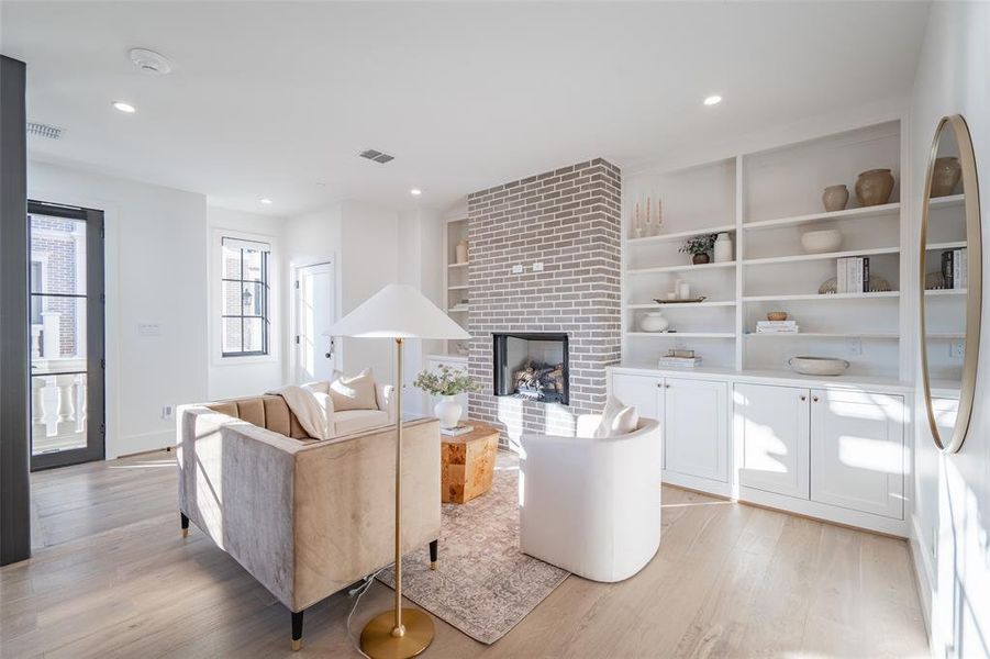 Living room featuring light hardwood / wood-style floors and a brick fireplace