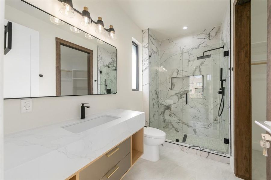 Bathroom with vanity, a marble finish shower, and a spacious closet Bathroom with vanity, a marble finish shower, and a spacious closet