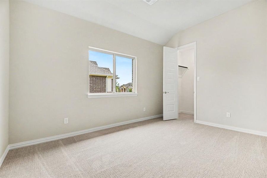 Carpeted room with a vaulted ceiling and a single window Carpeted room with a vaulted ceiling and a single window