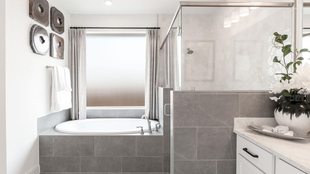 Bathroom featuring a stall shower, a garden tub, and vanity