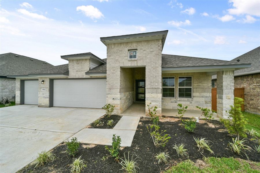 Modern brick ranch with three-car garage, sleek curb appeal, and sun-drenched interiors.