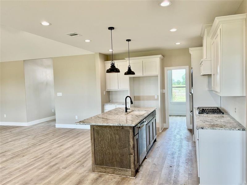 Kitchen featuring appliances with stainless steel finishes, light wood-style floors, white cabinets, light stone countertops, and recessed lighting Kitchen featuring appliances with stainless steel finishes, light wood-style floors, white cabinets, light stone countertops, and recessed lighting