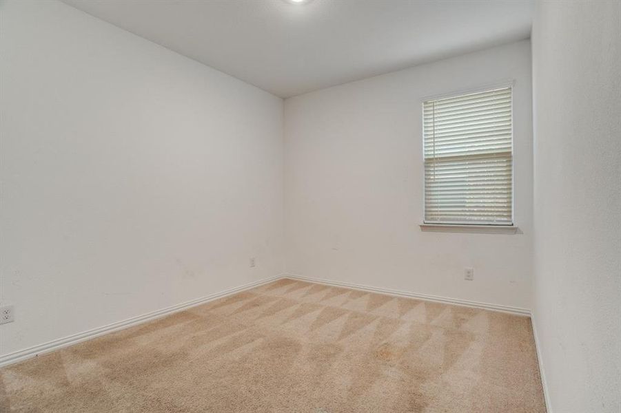 Spare room featuring light colored carpet and baseboards