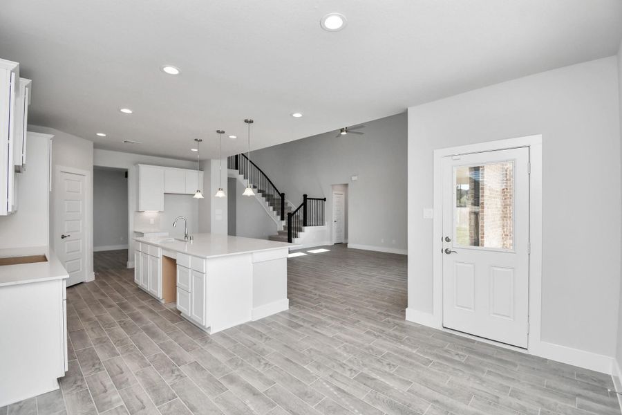 View from the breakfast area to the kitchen and living room. Sample photo of completed home with similar floor plan. Actual colors and selections may vary.