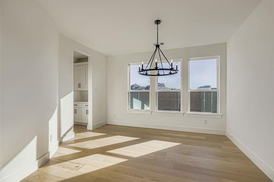 Unfurnished dining area with light wood-style flooring and a chandelier