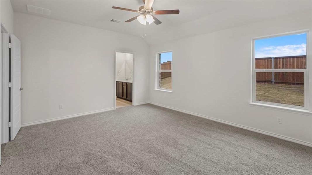 Empty room with lofted ceiling, light carpet, and a ceiling fan Empty room with lofted ceiling, light carpet, and a ceiling fan