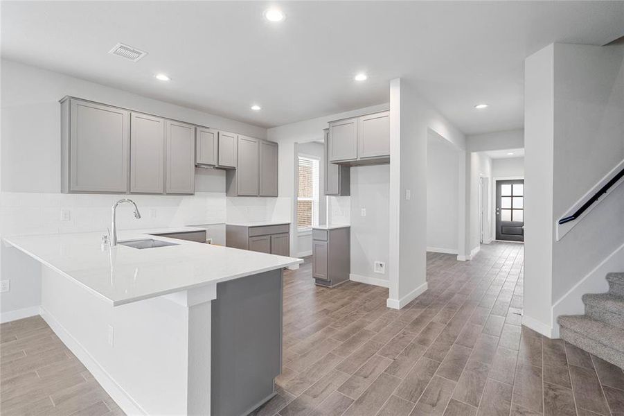 This kitchen is by far any chef’s dream! This spacious kitchen features high ceilings, stained wood cabinets, quartz countertops, SS appliances, modern tile backsplash, recessed lighting, extended counter space for breakfast bar, and a walk-in pantry all overlooking your huge family room.