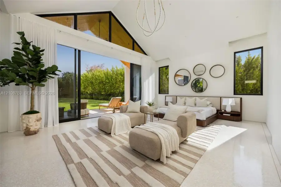 Vaulted ceiling with expansive glass gables, polished concrete flooring, sliding glass walls, and custom built-in headboard