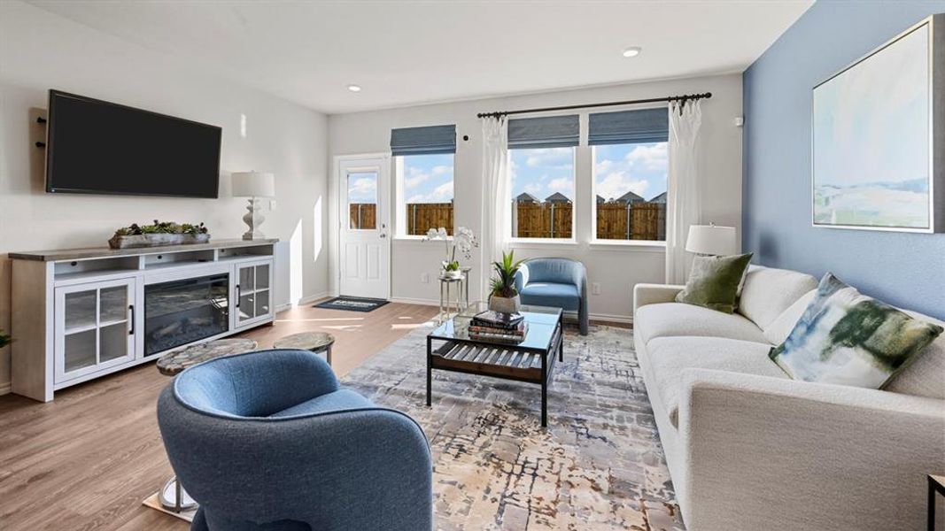 Living area with wood finished floors and a glass covered fireplace