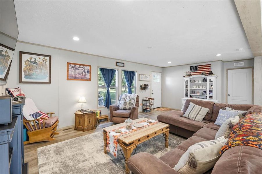 Living room featuring wood finished floors and recessed lighting Living room featuring wood finished floors and recessed lighting