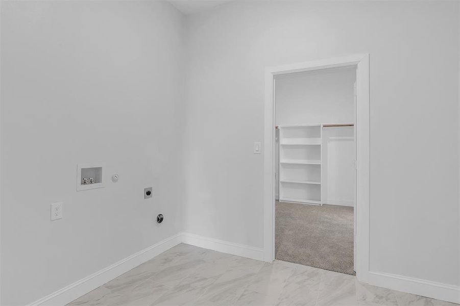 Laundry room featuring gas dryer hookup, hookup for an electric dryer, light carpet, and washer hookup