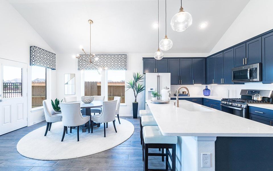Kitchen featuring appliances with stainless steel finishes, a sink, blue cabinetry, light countertops, and a center island with sink Kitchen featuring appliances with stainless steel finishes, a sink, blue cabinetry, light countertops, and a center island with sink