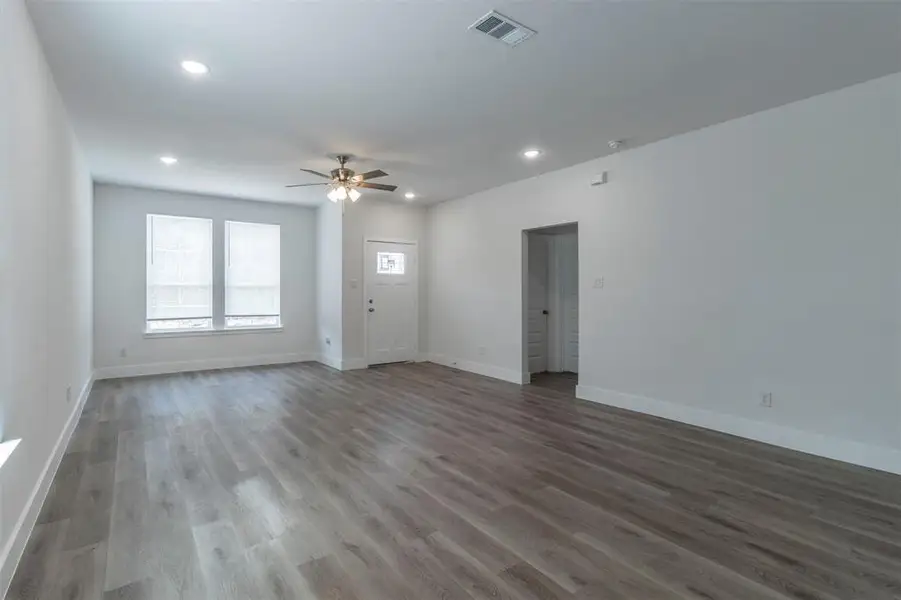 Empty room with hardwood / wood-style floors and ceiling fan