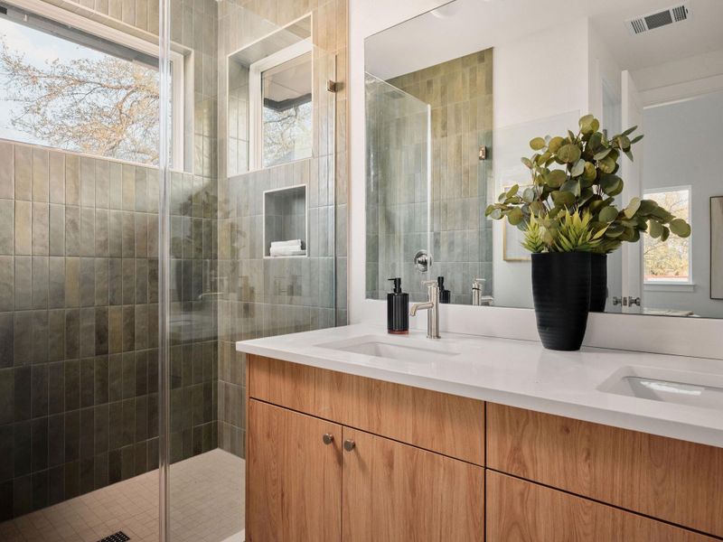 Bathroom with double vanity and a stall shower