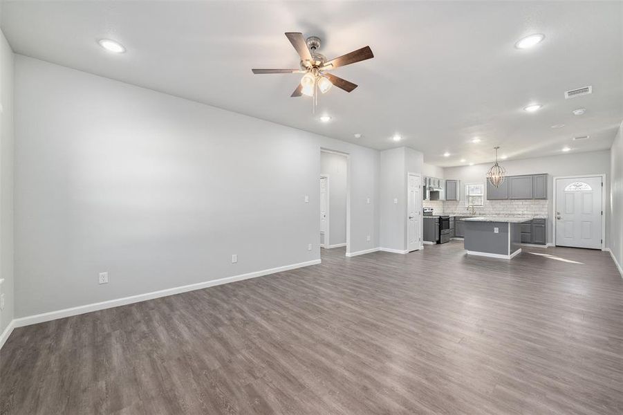 Unfurnished living room with ceiling fan, sink, and dark hardwood / wood-style floors