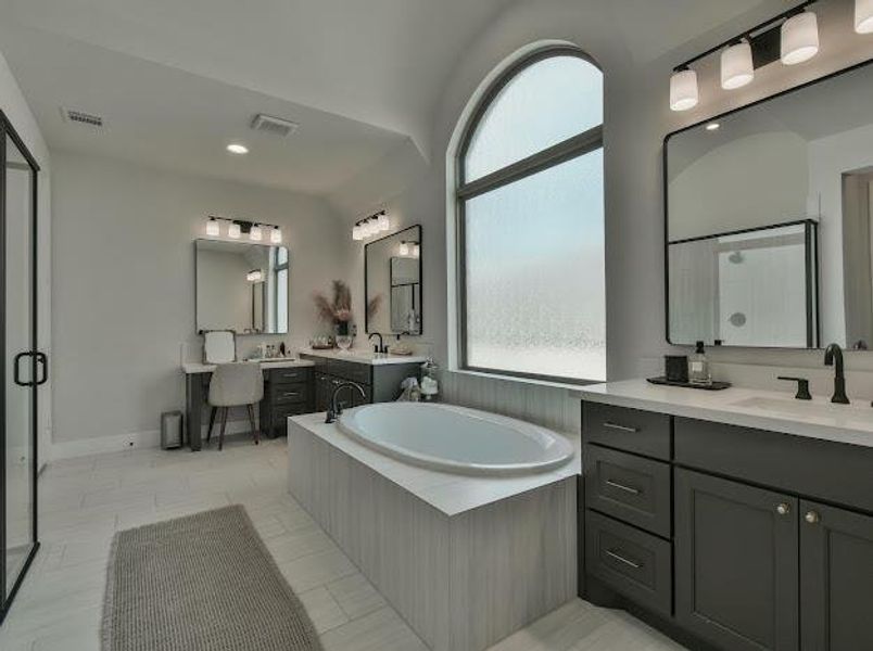 Bathroom with two vanities, a bath, a stall shower, recessed lighting, and light tile patterned floors Bathroom with two vanities, a bath, a stall shower, recessed lighting, and light tile patterned floors