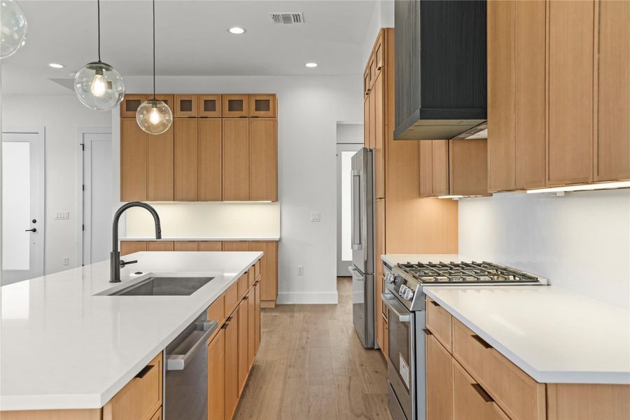 Culinary delights await in this modern kitchen with pristine counters and an oversized central island.