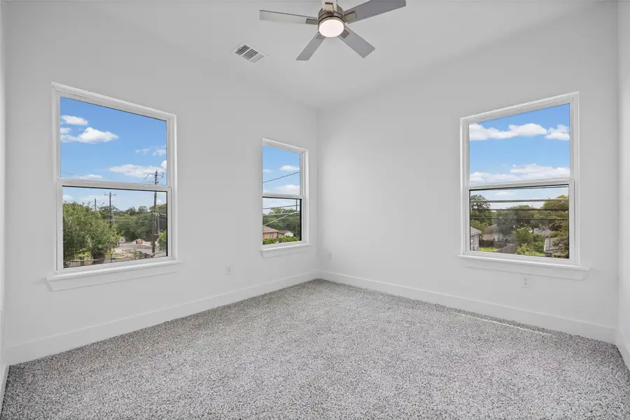 A spacious bedroom provides a serene retreat, complete with three windows and carpeted flooring. A spacious bedroom provides a serene retreat, complete with three windows and carpeted flooring.