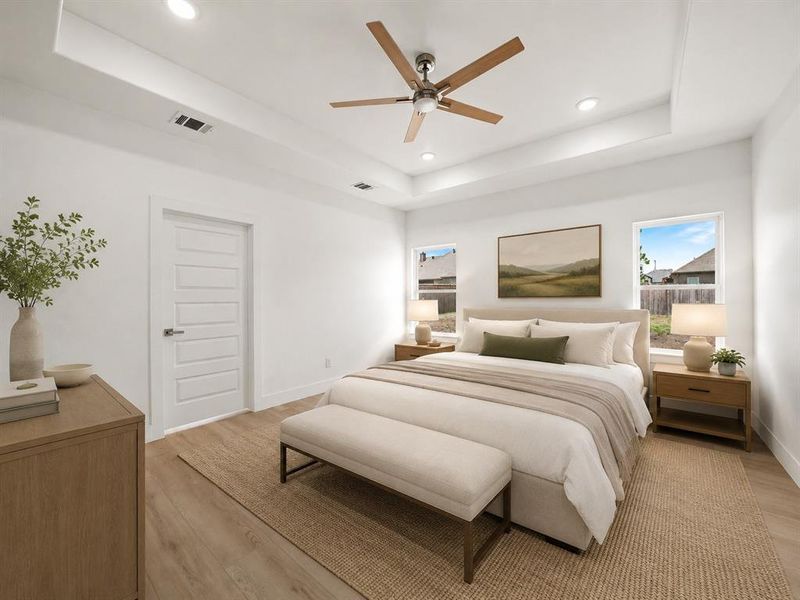 Spacious room featuring a tray ceiling with recessed lighting and a contemporary ceiling fan Spacious room featuring a tray ceiling with recessed lighting and a contemporary ceiling fan