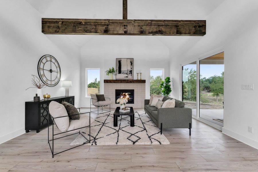 A spacious, naturally illuminated great room boasts a cozy fireplace and soaring vaulted ceilings, perfect for gatherings. A spacious, naturally illuminated great room boasts a cozy fireplace and soaring vaulted ceilings, perfect for gatherings.