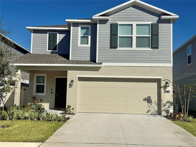 Front exterior of a new home in Hunt Club Groves: Manor Key Collection, Lake Wales, FL, highlighting curb appeal (Image 1). Front exterior of a new home in Hunt Club Groves: Manor Key Collection, Lake Wales, FL, highlighting curb appeal (Image 1).