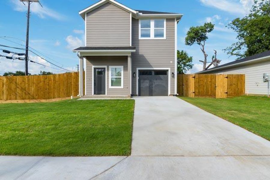 View of front of home with concrete driveway and an attached garage