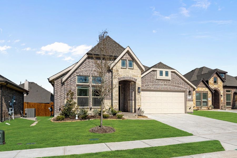 Single-story brick and stone home with arched entry, two-car garage, and manicured front lawn Single-story brick and stone home with arched entry, two-car garage, and manicured front lawn