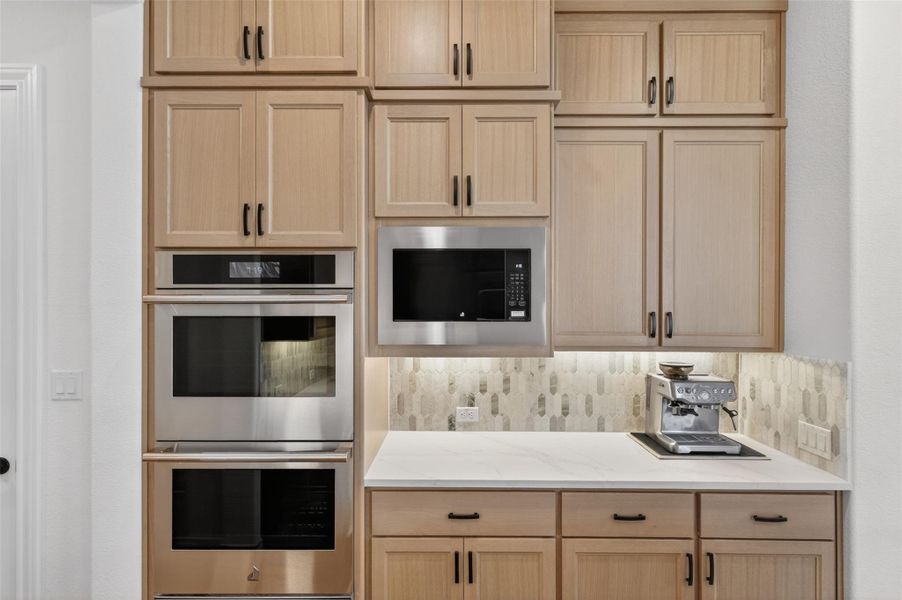 Streamlined kitchen design features integrated stainless steel appliances and abundant cabinetry. Streamlined kitchen design features integrated stainless steel appliances and abundant cabinetry.
