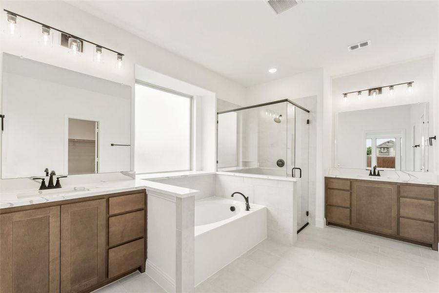 Master bathroom with dual vanities, soaking tub, and glass walk-in shower with white tile floors Master bathroom with dual vanities, soaking tub, and glass walk-in shower with white tile floors