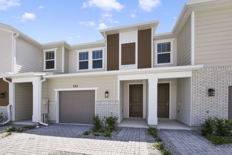 Front exterior of a new home in Towns at Riverwalk, Sanford, FL, highlighting curb appeal (Image 1). Front exterior of a new home in Towns at Riverwalk, Sanford, FL, highlighting curb appeal (Image 1).