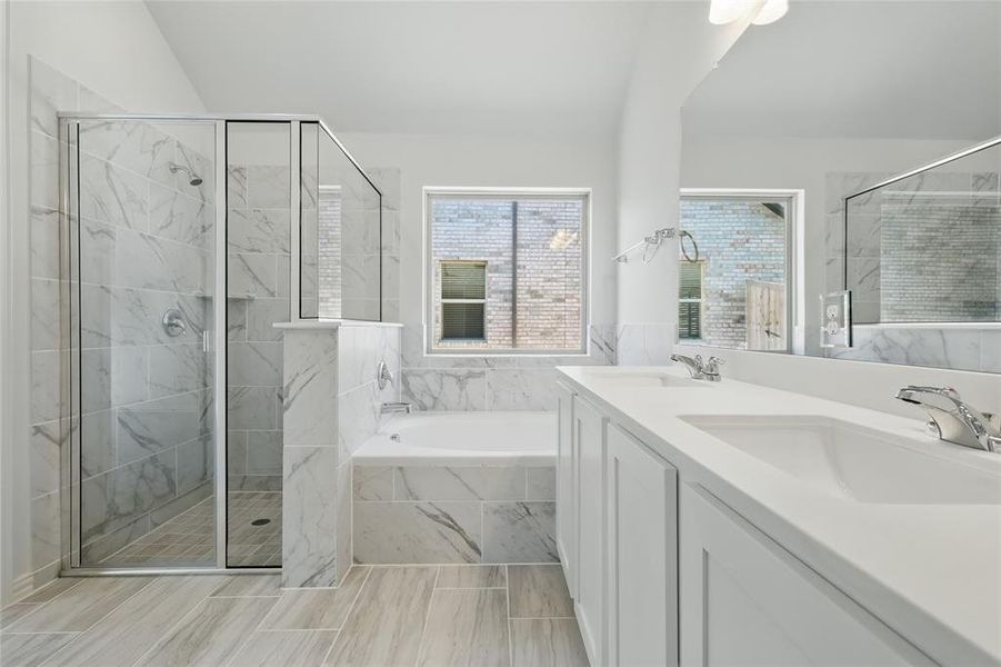 Full bathroom with a bath, a stall shower, double vanity, and a sink