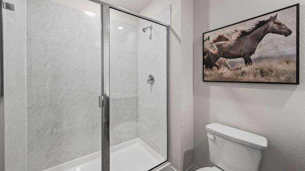 Full bath featuring a stall shower and a textured wall